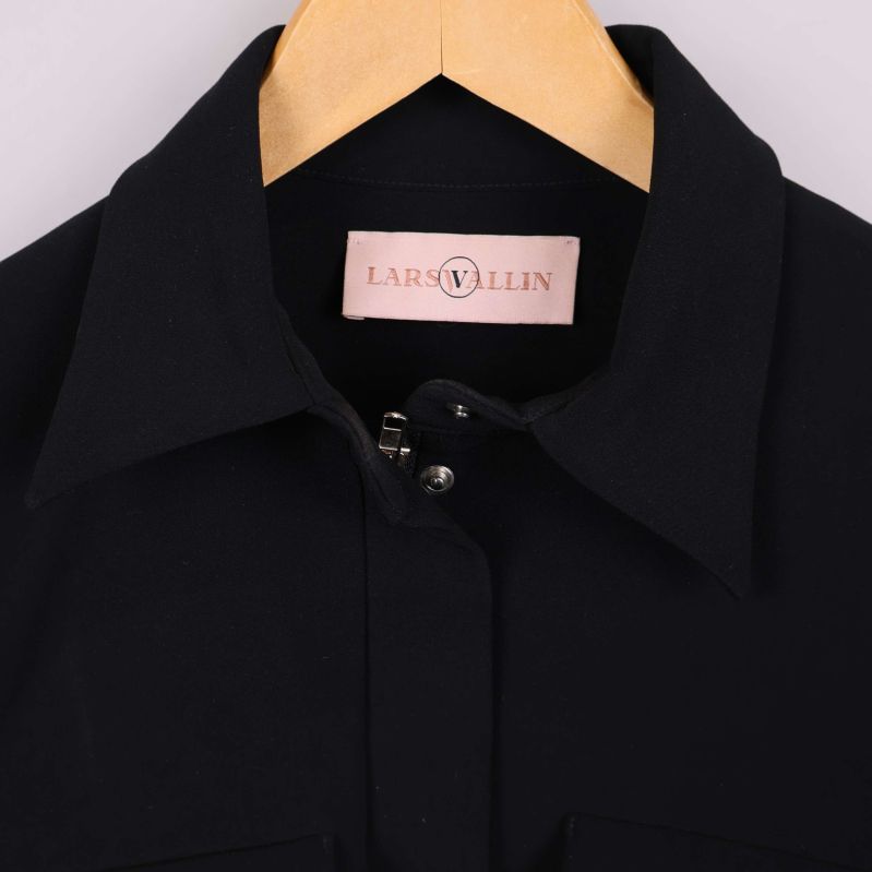 Närbild på krage och Lars Wallin-märke på jackan