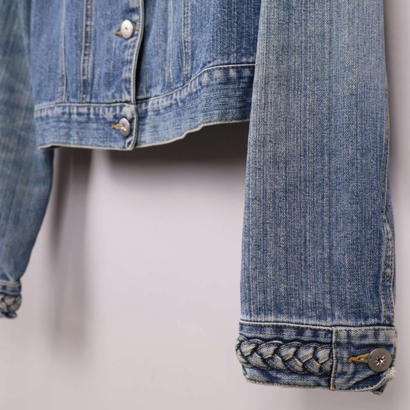 Närbild på ärmslut med flätad denimdetalj