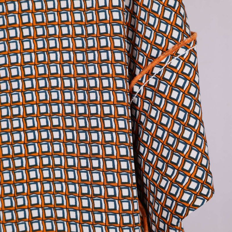 Närbild på ärmslut och kontrastdetalj på mönstrad tunika