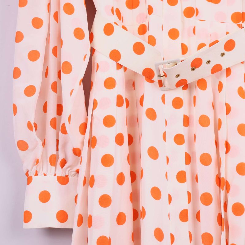 Närbild på ärm och bälte med prickigt mönster