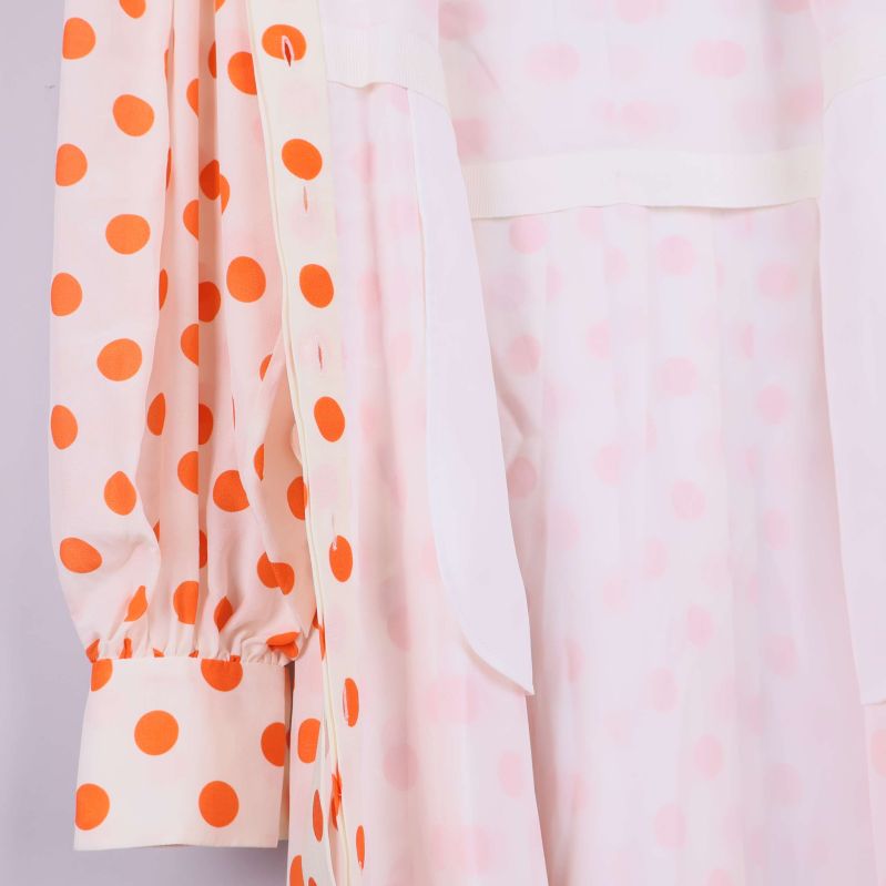 Insida av prickig klänning samt foder visas i närbild