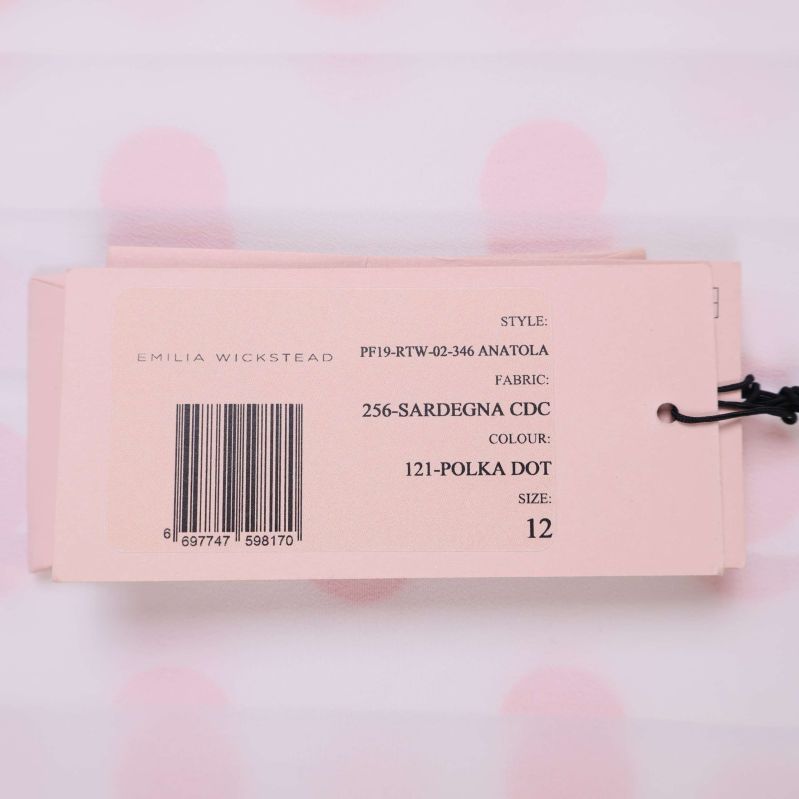 Etikett med material- och färginformation på prickig klänning