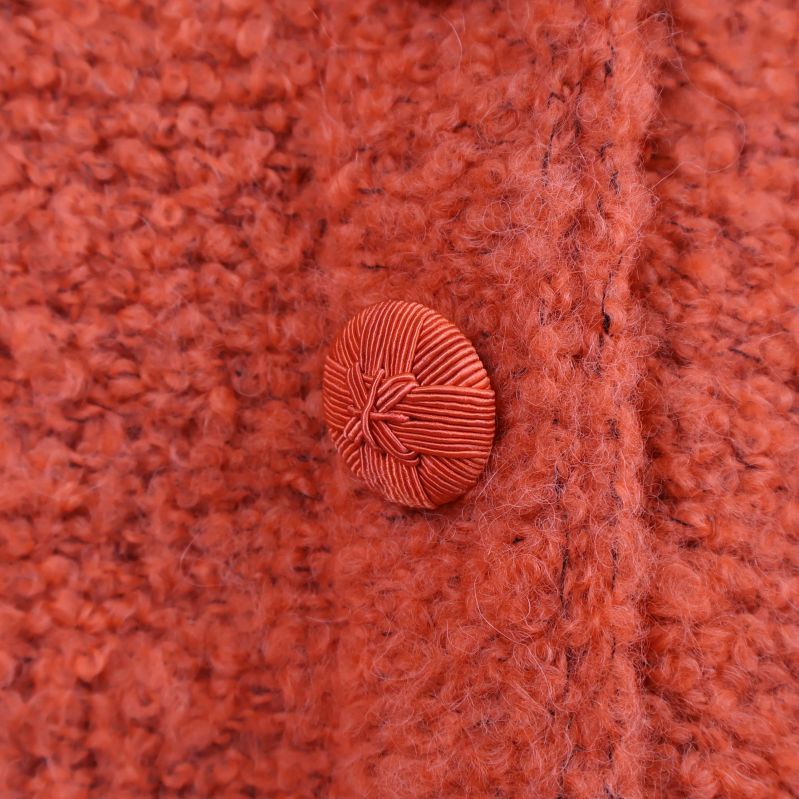 Närbild på en av de runda knapparna i garn