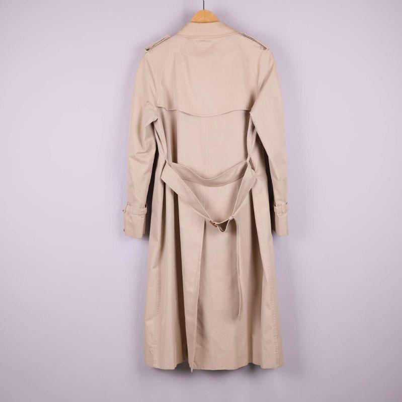 Beige trenchcoat, bältad syns bakifrån