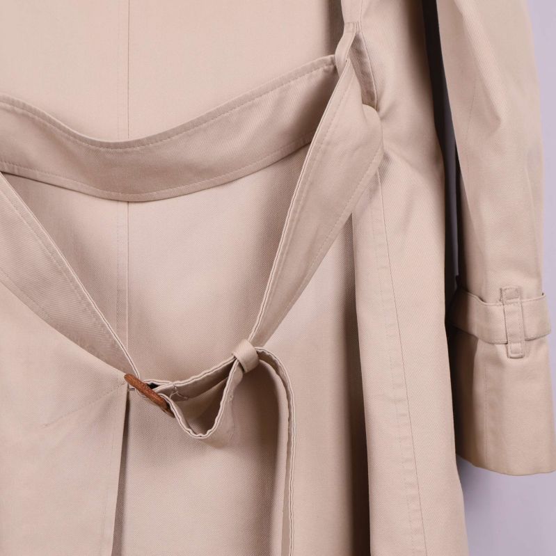 Knytband och baksida av trenchcoat visas nära