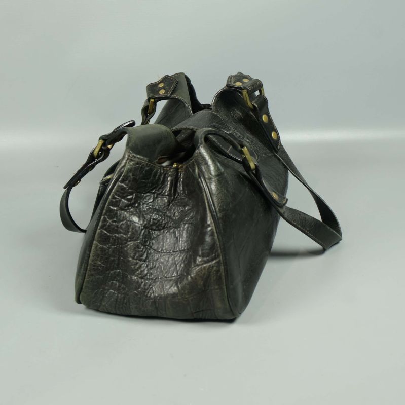 Sida av väska med texturerad yta och handtag