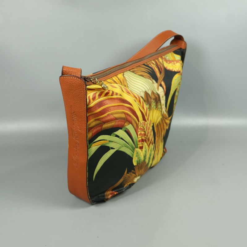 Sidoform på väska med bruna detaljer och blixtlås