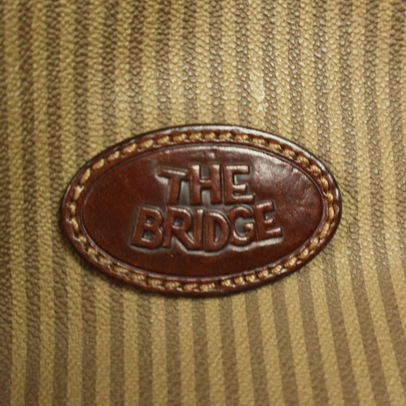 Närbild på logotypen The Bridge på väska