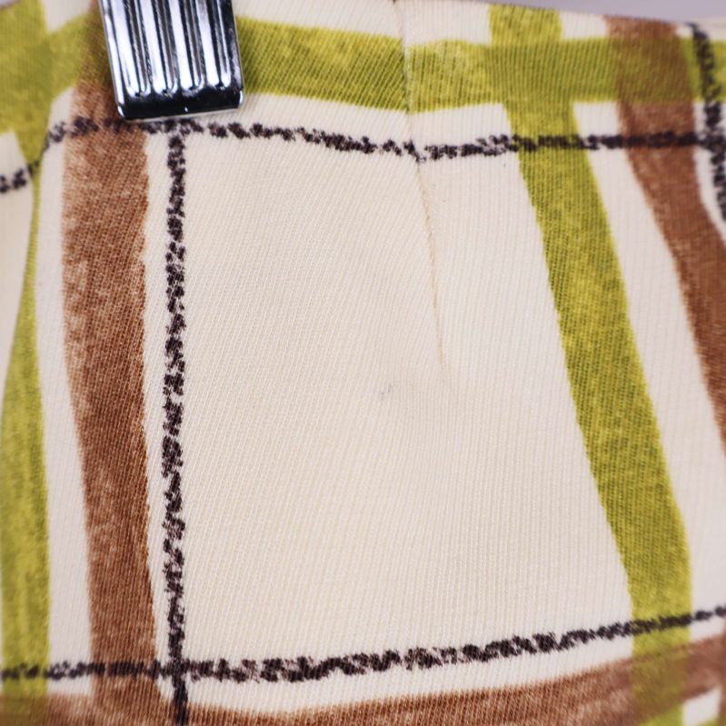 Närbild på ficka och rutigt mönster på byxans sida