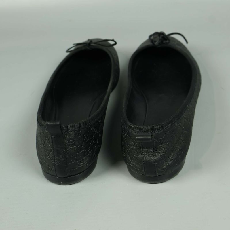 Baksidan av svarta ballerinaskor med dekorativ detalj