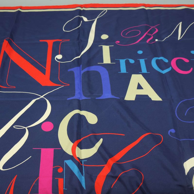 Detalj av stora bokstäver på blå scarf