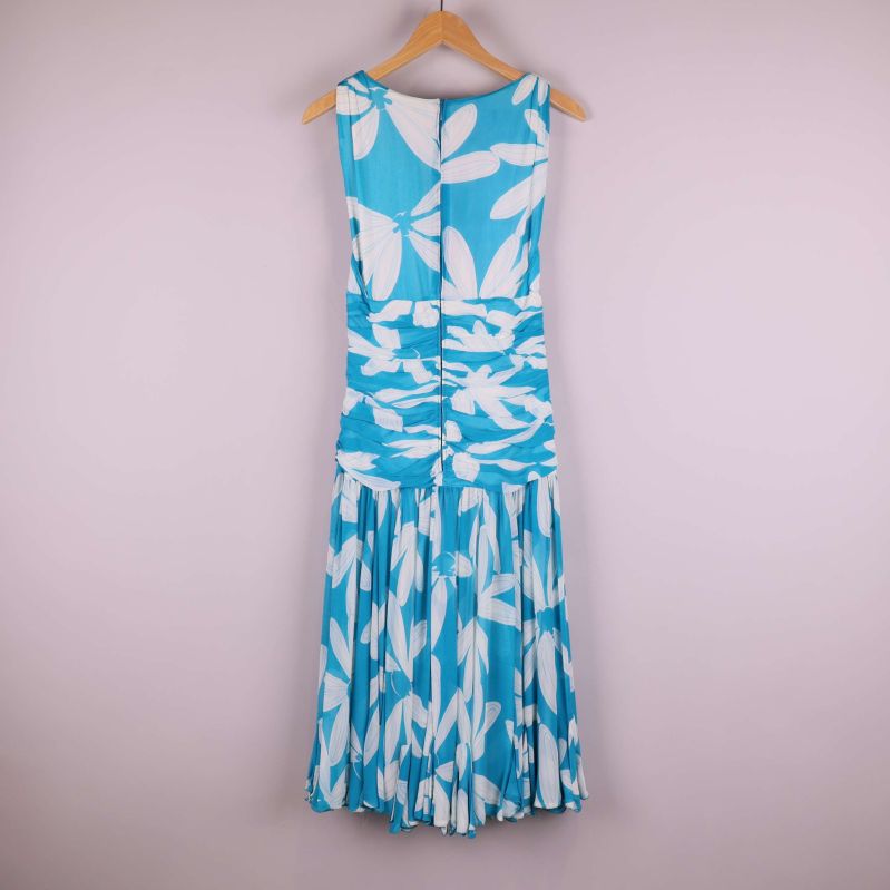 Baksida av blåvit plisserad klänning med blommönster