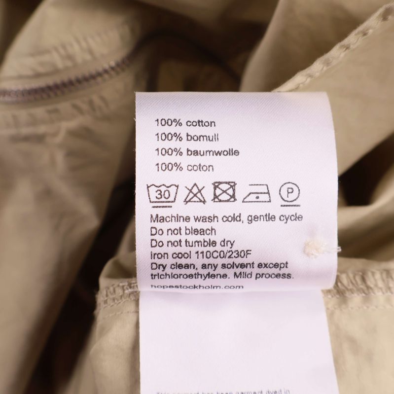 Materialetikett med texten 100% bomull och tvättråd