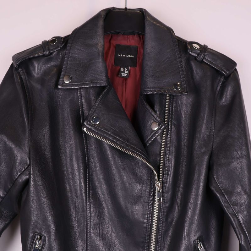 Detaljbild på axlar och krage med nitar och dragkedja