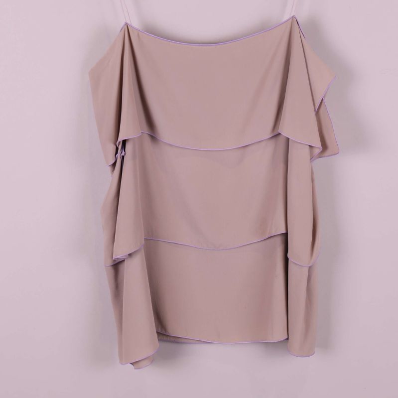 Närbild på volanger och tygstruktur i toppen