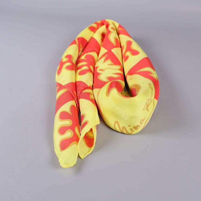 Scarf ihoprullad på ljus yta, visar färg och tyg