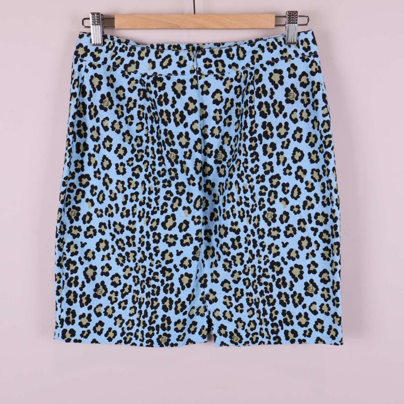 Baksidan av ljusblå kjol med leopardmönster på galge