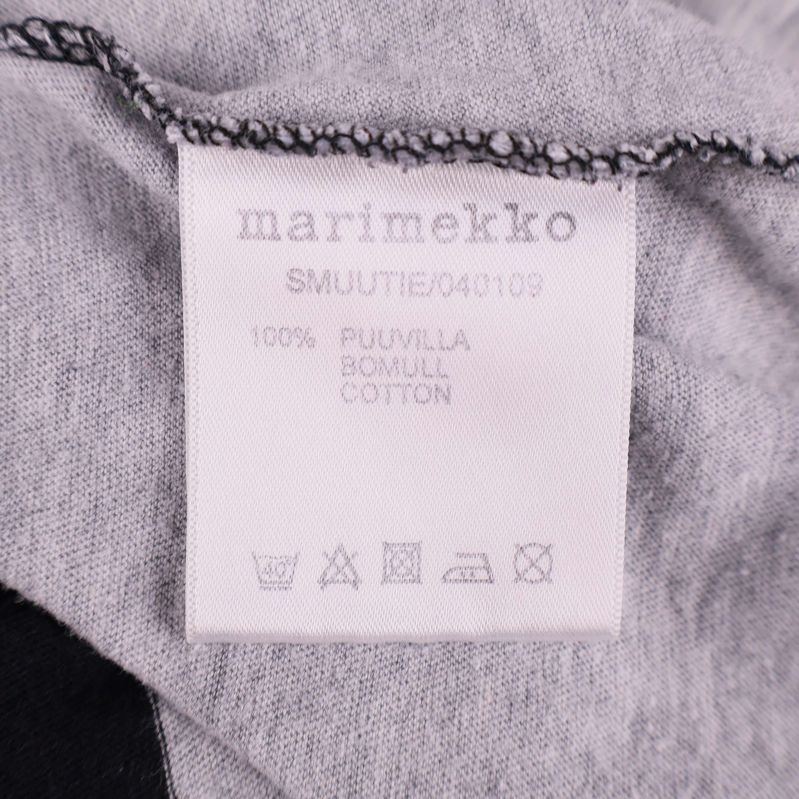 Materiallapp som visar 100% bomull i tunikan