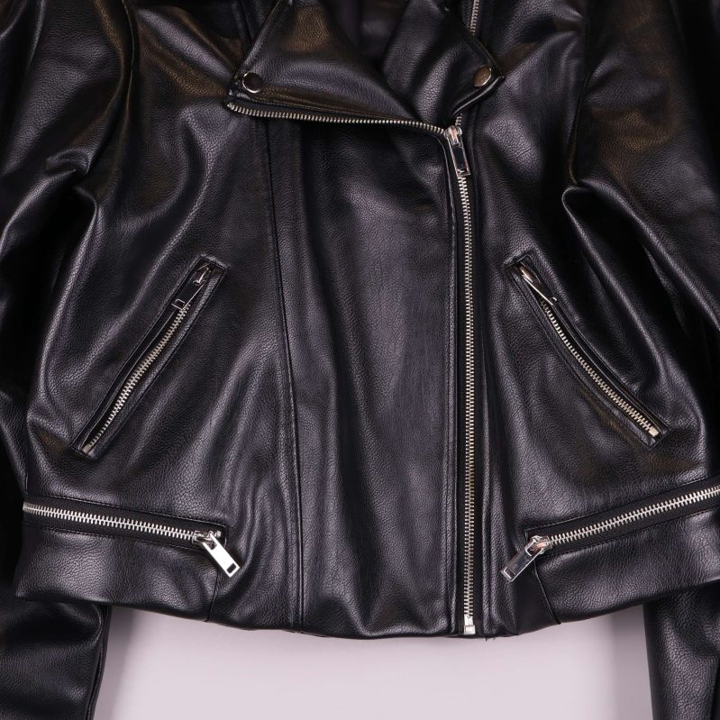 Närbild på dragkedjor och fickor framtill på jackan