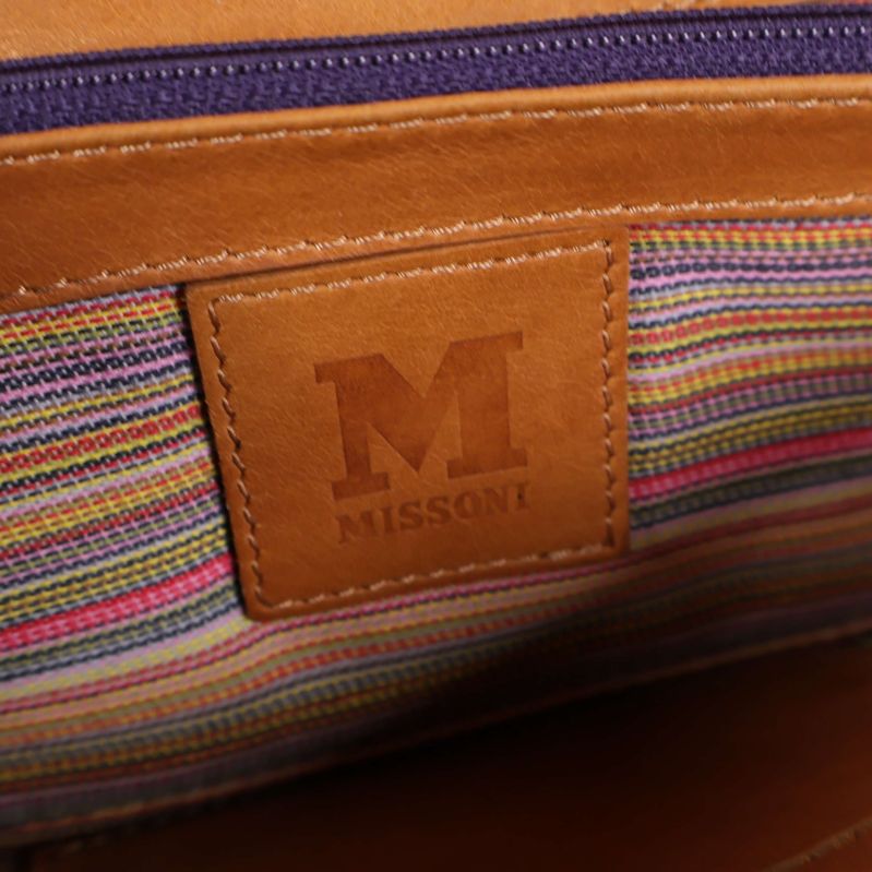Närbild av M Missoni-logotyp och randigt tyg invändigt