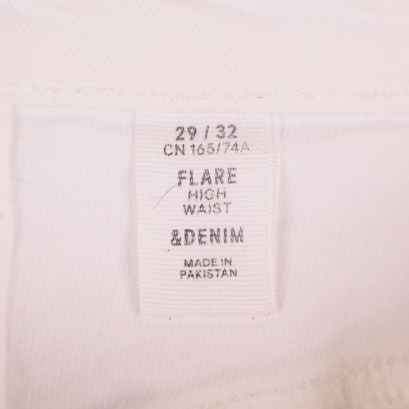 Närbild på etikett med texten 'FLARE HIGH WAIST &DENIM'
