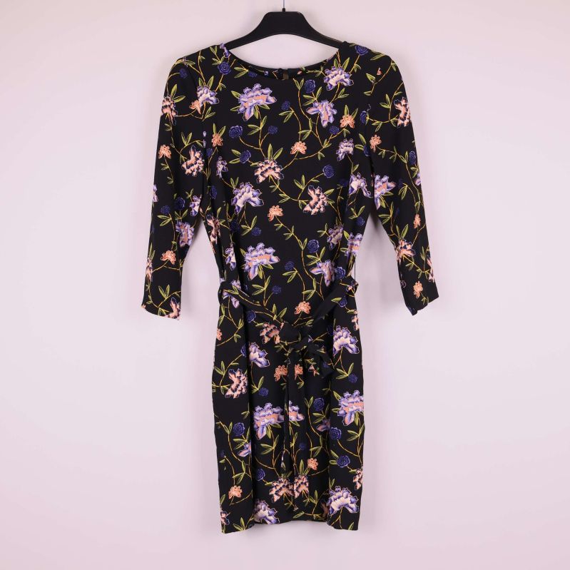 Framsidan av svart blommig klänning med knytband