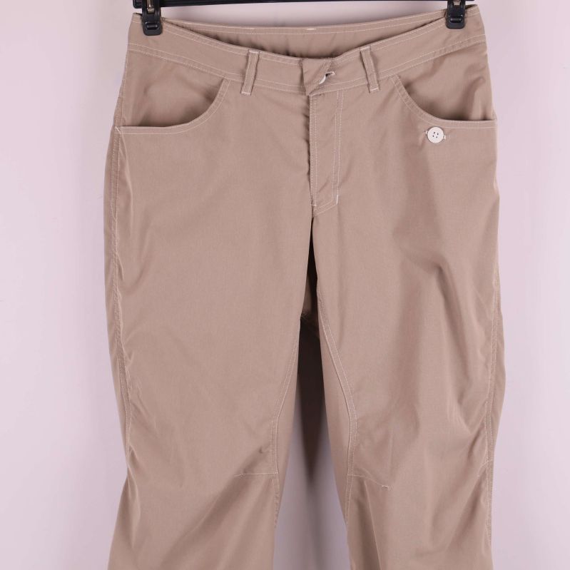 Framsida av byxor med fickor och knappdetalj