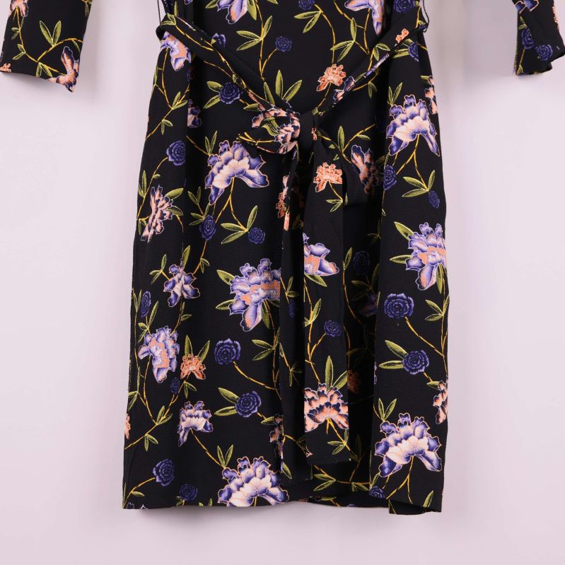 Närbild på kjoldelens knytband och blommönster