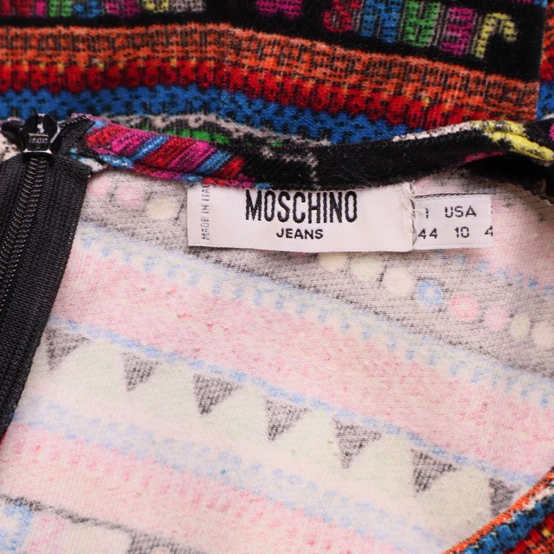 Närbild på etikett med Moschino Jeans och storleksinformation i klänningen