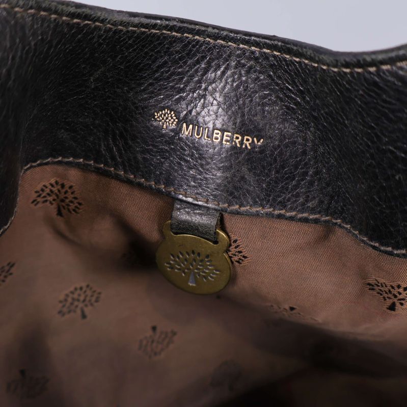 Närbild av Mulberry-loggan tryckt på brunt innerfoder inuti väskan