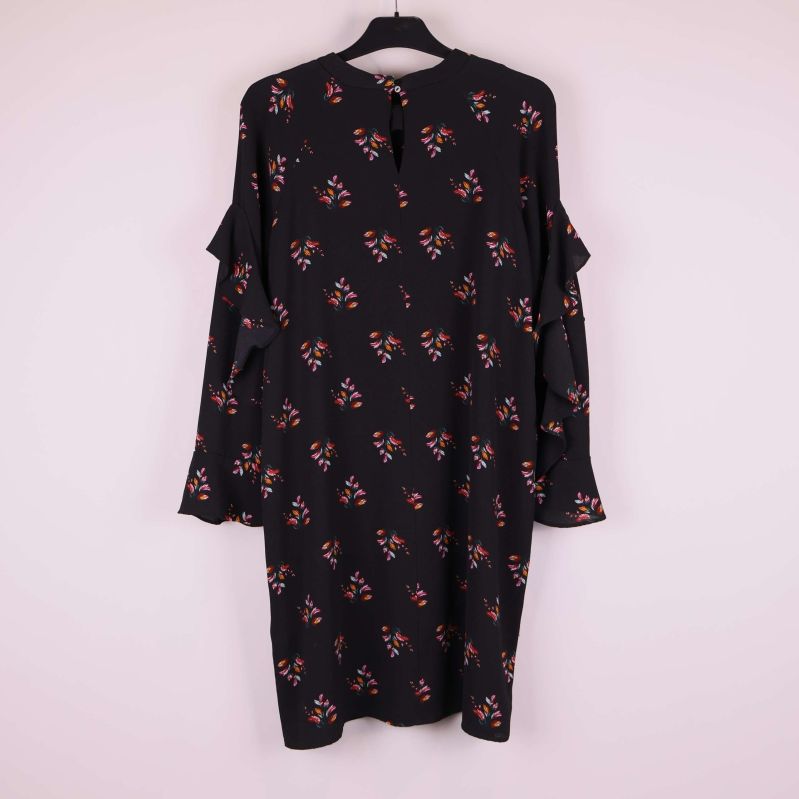 Klänningens baksida visar volanger och blommigt mönster