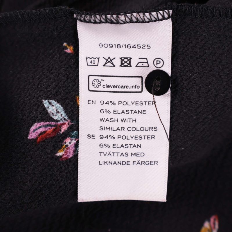 Tvättrådsetikett med materialinformation och tvättsymboler