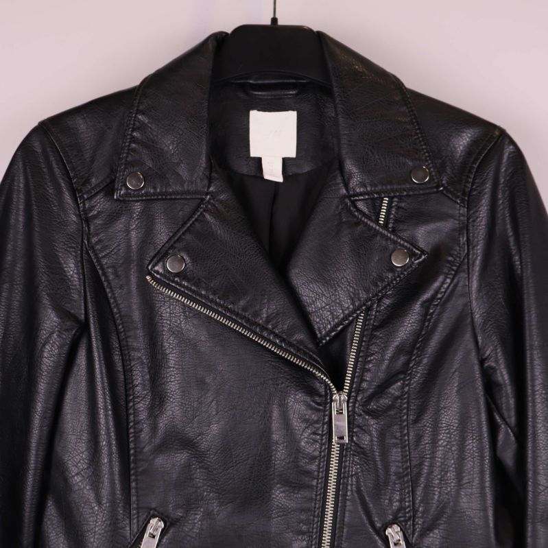 Närbild på krage och framstycke av svart skinnjacka