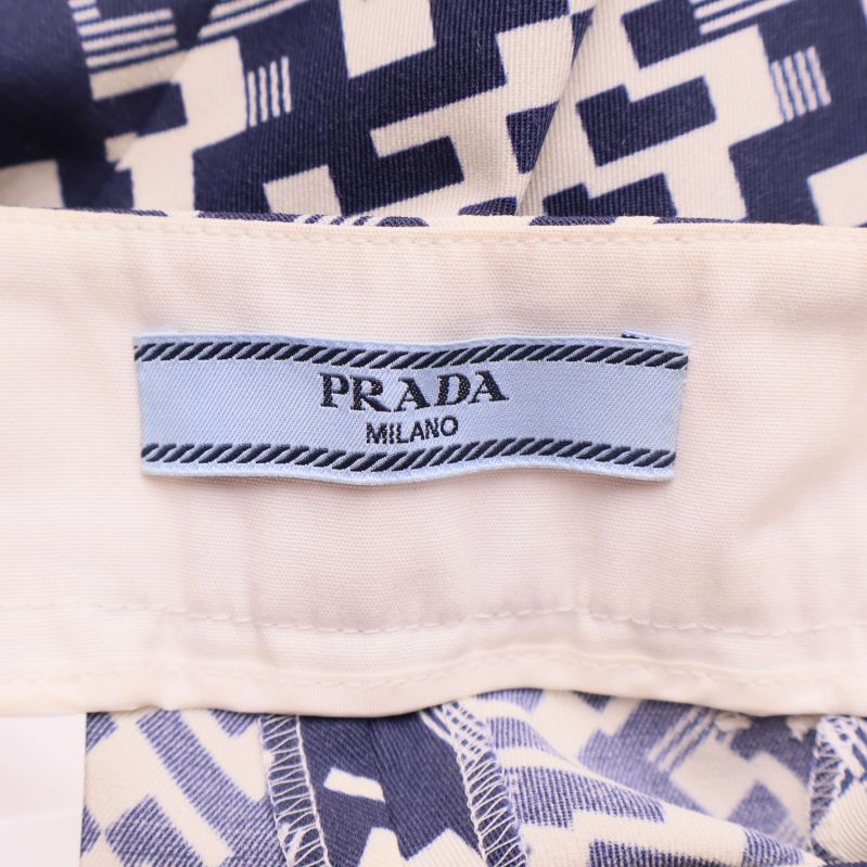 Närbild på ljusblå etikett med Prada Milano-logga i midjan