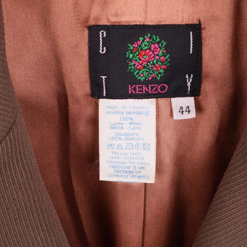Närbild på Kenzo-märkning och materialetikett med storlek 44