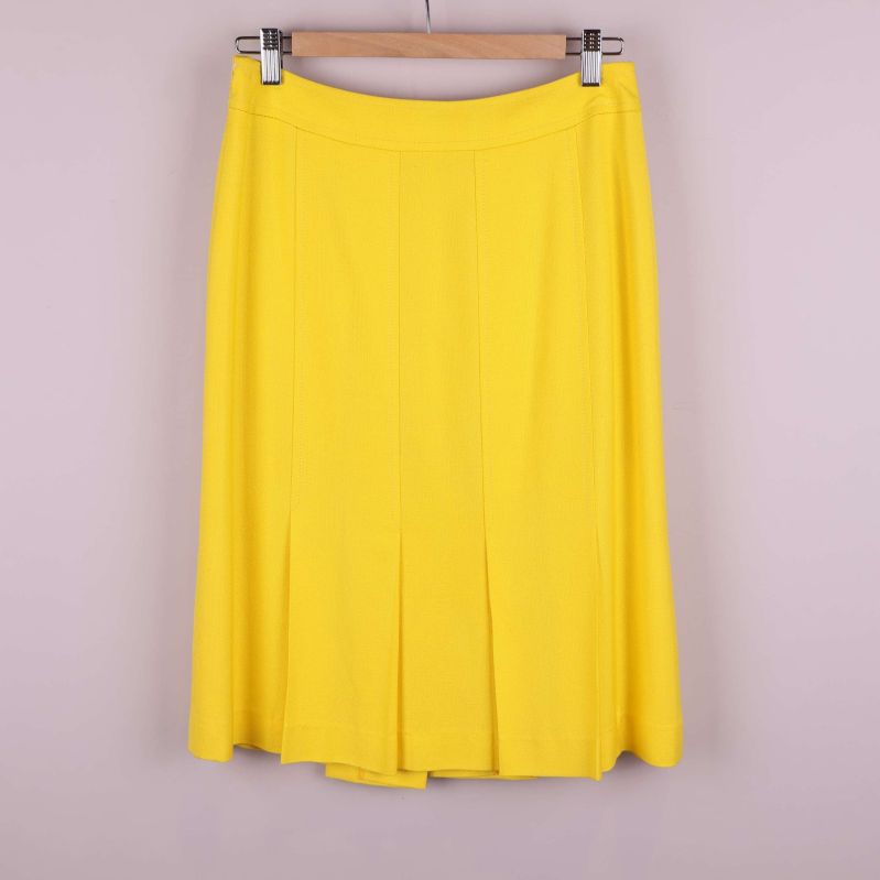 Baksida av gul kjol på galge, veckad nederdel