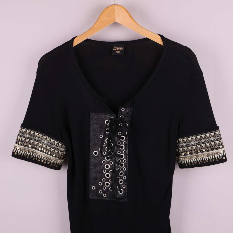 Närbild av toppens framsida med snörning och nitar