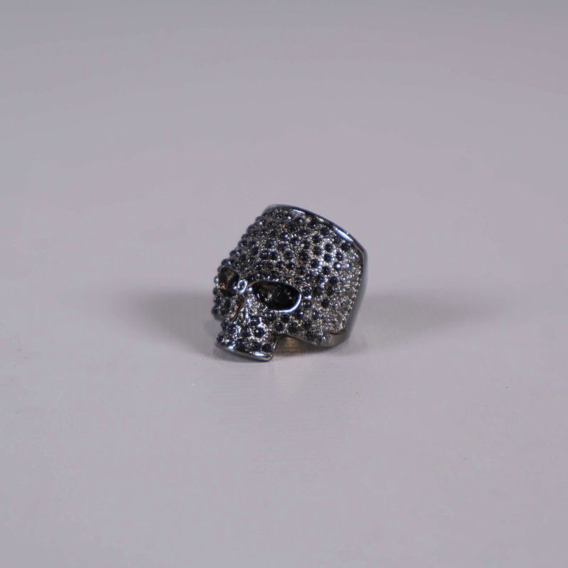 Ring med dödskallemotiv liggandes, stenar i hela fronten