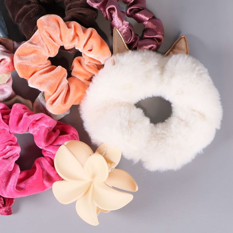 Närbild på vit fluffig scrunchie med små öron och hårklämma
