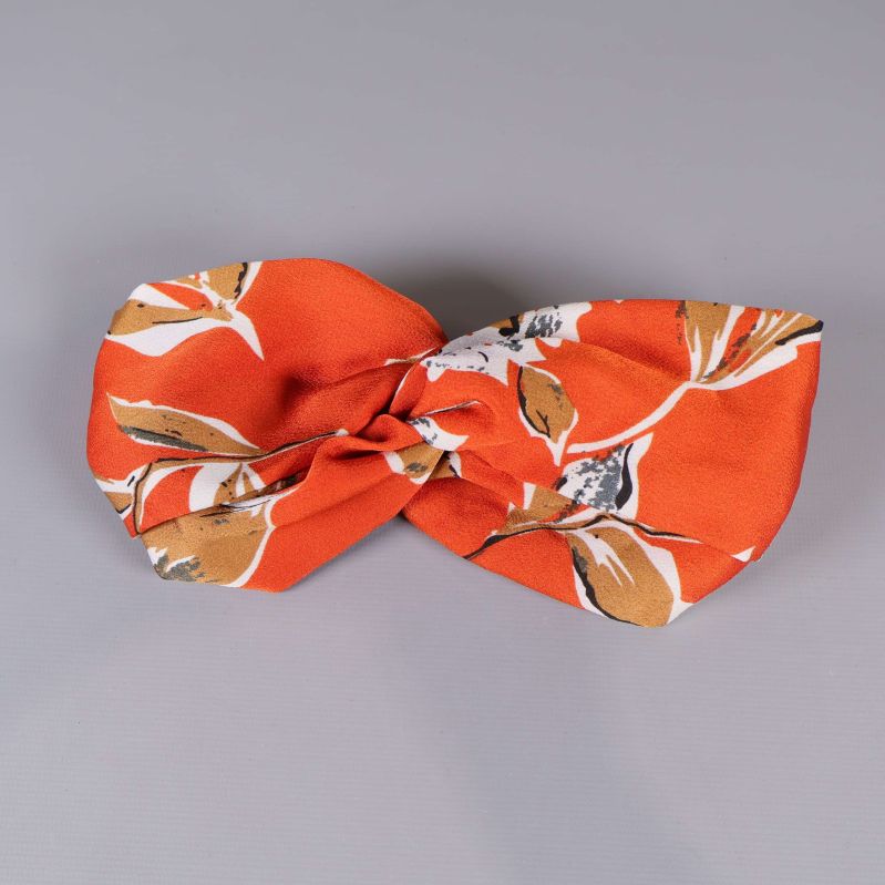 Framsida av hårband med twist och blommönster