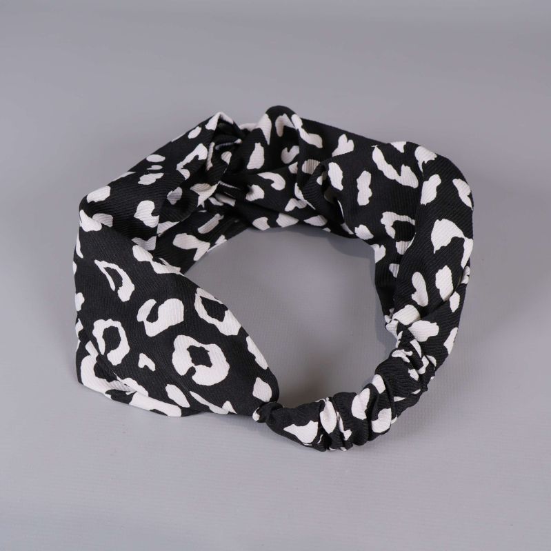 Detaljbild på svartvitt hårband med grafiskt mönster