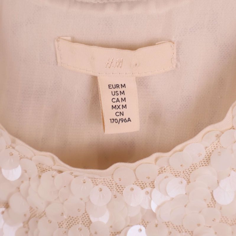 Närbild på H&M etikett och storlekslapp i klänning