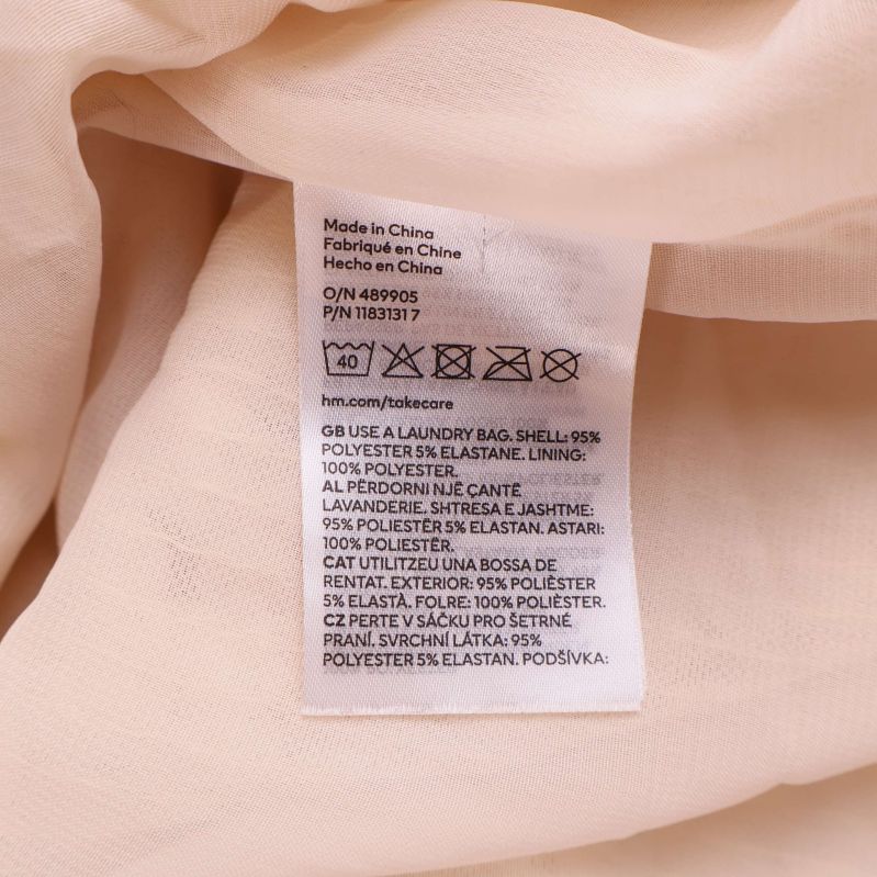 Materialetikett inuti paljettklänning med tvättråd