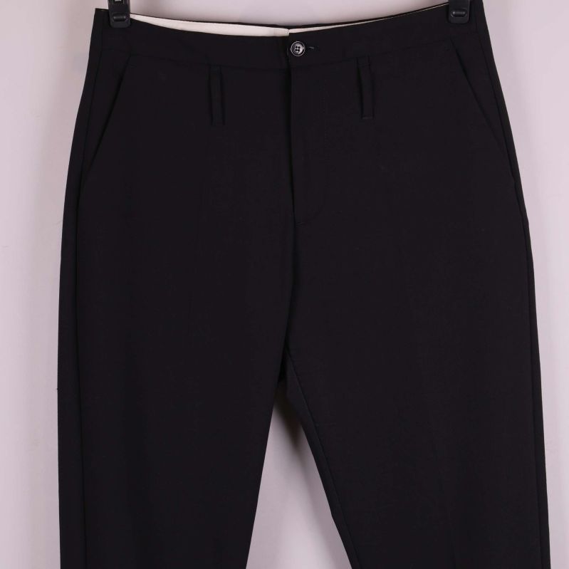 Närbild på överdelen av svarta kostymbyxor med fickor