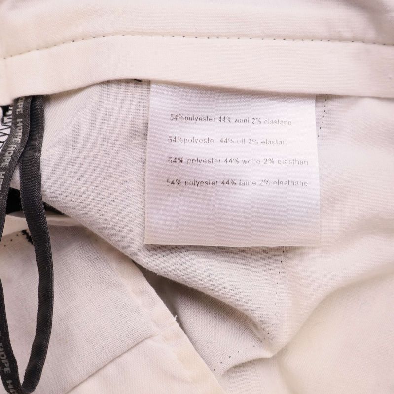 Materiallapp som anger 54% polyester, 44% ull, 2% elastan