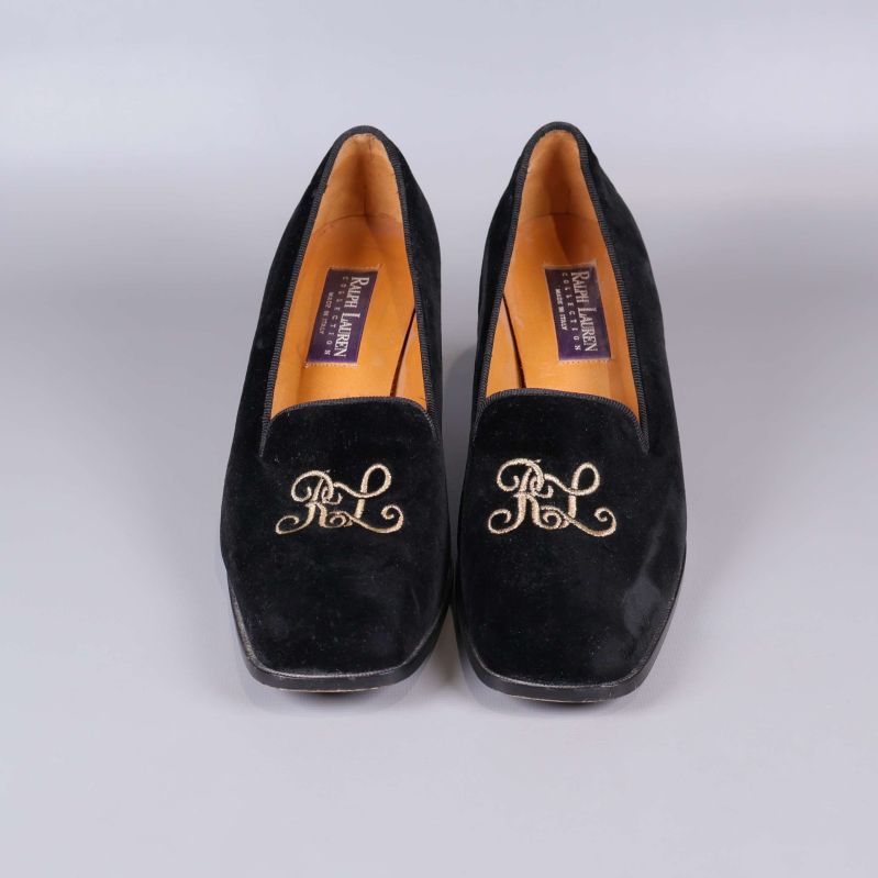 Framsidan av pumps med guldigt RL-monogram