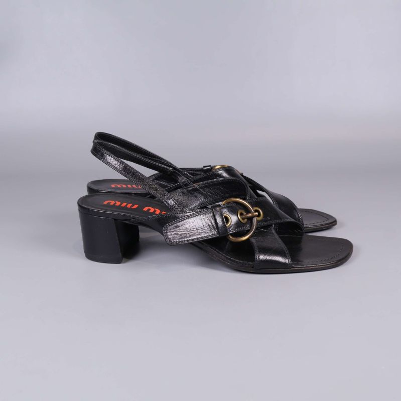 Sidovy av svart Miu Miu sandal med metallspänne och blockklack