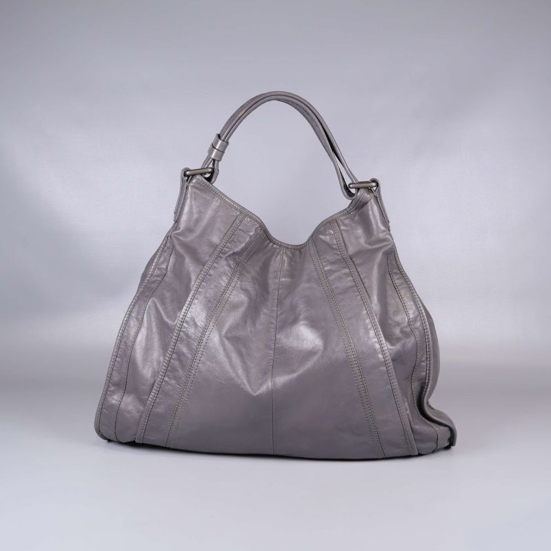 Väskans baksida visar jämn grå yta och sömmar