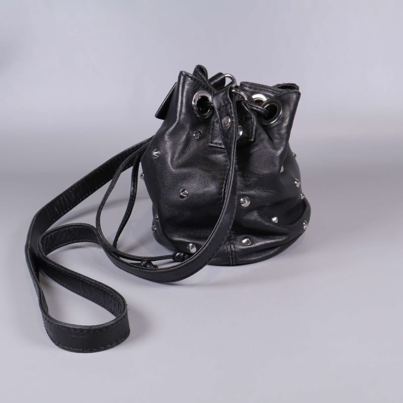 Bakre sida av svart bucket bag med nitar och axelrem