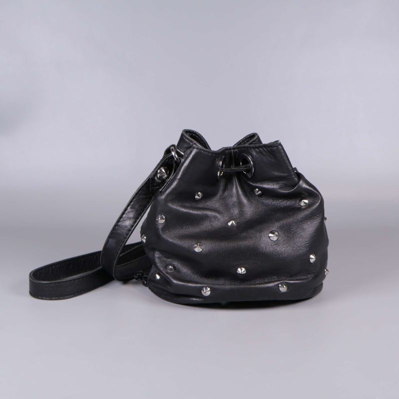 Bucket bag sedd bakifrån med dekorativa nitar och lång rem